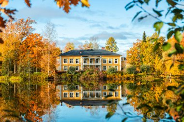 Kouvola, Finlandiya - 8 Ekim 2019: Güzel ahşap Rabbelugn Malikanesi ile sonbahar manzarası - Takamaan Kartano. Wrede aile evi 1820 'de Kymijoki nehri kıyısında inşa edildi..