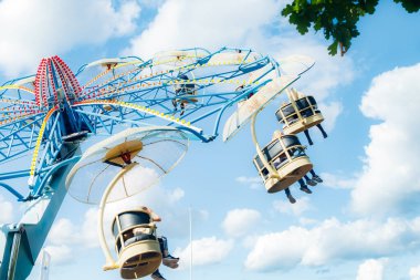 Güneşli bir günde lunaparkta atlıkarıncaya bin.