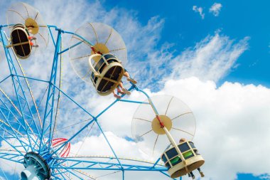 Güneşli bir günde lunaparkta atlıkarıncaya bin.