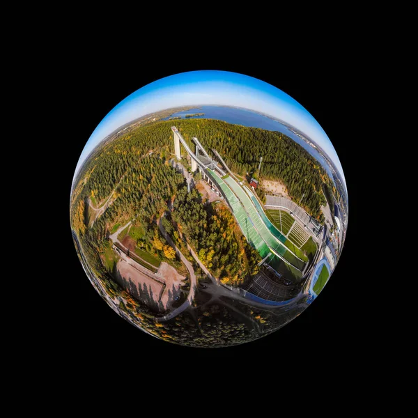 A three dimensional aerial panoramic view of Lahti sports centre with three ski jump towers, in a mini planet panorama style.