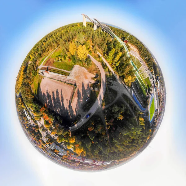 A three dimensional aerial panoramic view of Lahti sports centre with three ski jump towers, in a mini planet panorama style.