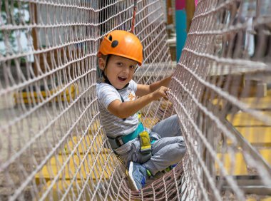 Küçük bir dağcı bir ip üzerinde bir düğüm kravat. Bir kişi tırmanış için hazırlanıyor. Çocuk bir düğüm kravat öğrenir. Dağcılık için sigorta denetleme.