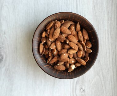 Arka plan görüntüsü için sağlıklı gıda kadar badem fındık kapatın. Doku beyaz gri masa üstü görünümünde. Fındık Kupası plaka üzerinde