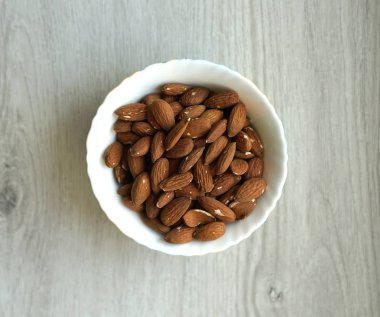 Arka plan görüntüsü için sağlıklı gıda kadar badem fındık kapatın. Doku beyaz gri masa üstü görünümünde. Fındık Kupası plaka üzerinde