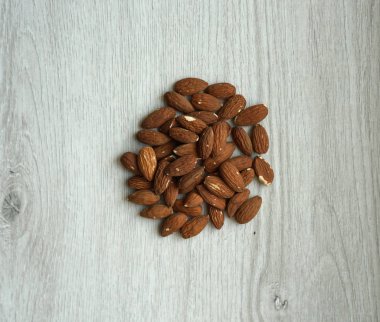 Arka plan görüntüsü için sağlıklı gıda kadar badem fındık kapatın. Doku beyaz gri masa üstü görünümünde. Fındık Kupası plaka üzerinde