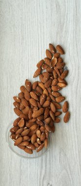 Arka plan görüntüsü için sağlıklı gıda kadar badem fındık kapatın. Doku beyaz gri masa üstü görünümünde. Fındık Kupası plaka üzerinde