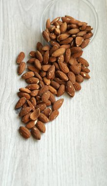 Arka plan görüntüsü için sağlıklı gıda kadar badem fındık kapatın. Doku beyaz gri masa üstü görünümünde. Fındık Kupası plaka üzerinde