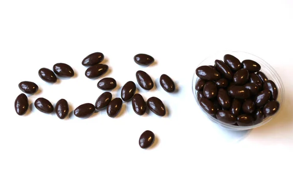 Lebensmittel Bild Nahaufnahme Bonbons, Schokoladenmilch, extra dunkle Mandelnüsse. Liebe Textur auf weiß grauen Tischplatte Ansicht Hintergrund auf dem Teller — Stockfoto