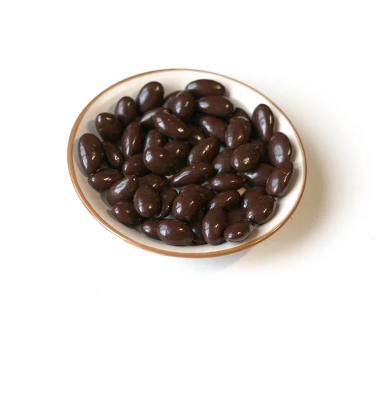 Food image close up candy, chocolate milk, extra dark almond nuts. Texture on top view background on the cup plate — Stock Photo, Image