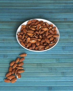 Arka plan görüntüsü için sağlıklı gıda kadar badem fındık kapatın. Doku fındık Kupası plaka üzerinde