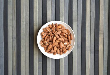 Arka plan görüntüsü için sağlıklı gıda kadar badem fındık kapatın. Doku fındık Kupası plaka üzerinde