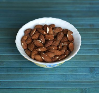 Arka plan görüntüsü için sağlıklı gıda kadar badem fındık kapatın. Doku fındık Kupası plaka üzerinde