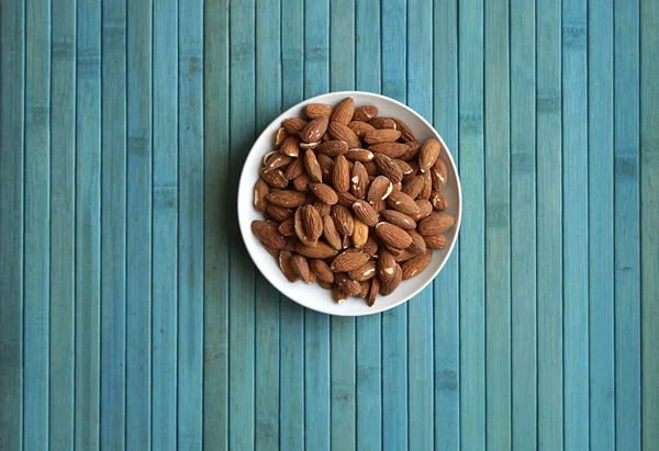 Arka plan görüntüsü için sağlıklı gıda kadar badem fındık kapatın. Doku fındık Kupası plaka üzerinde