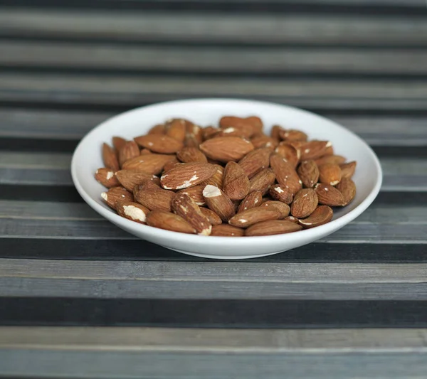 Healthy food  for background image close up almond nuts. Texture Nuts on the cup plate — Stock Photo, Image