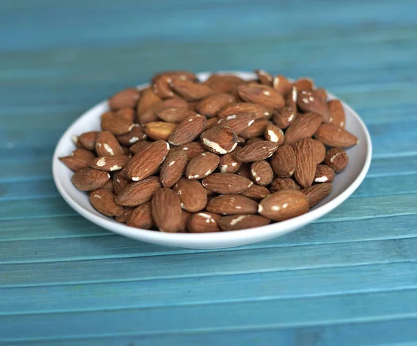 Arka plan görüntüsü için sağlıklı gıda kadar badem fındık kapatın. Doku fındık Kupası plaka üzerinde