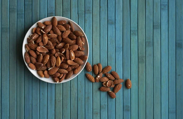 Arka plan görüntüsü için sağlıklı gıda kadar badem fındık kapatın. Doku fındık Kupası plaka üzerinde