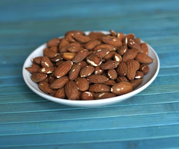 Arka plan görüntüsü için sağlıklı gıda kadar badem fındık kapatın. Doku fındık Kupası plaka üzerinde