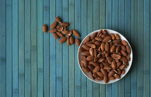 Arka plan görüntüsü için sağlıklı gıda kadar badem fındık kapatın. Doku fındık Kupası plaka üzerinde