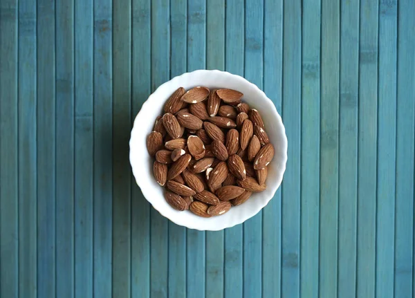 Arka plan görüntüsü için sağlıklı gıda kadar badem fındık kapatın. Doku fındık Kupası plaka üzerinde