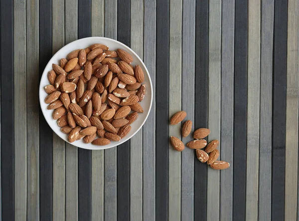 Arka plan görüntüsü için sağlıklı gıda kadar badem fındık kapatın. Doku fındık Kupası plaka üzerinde