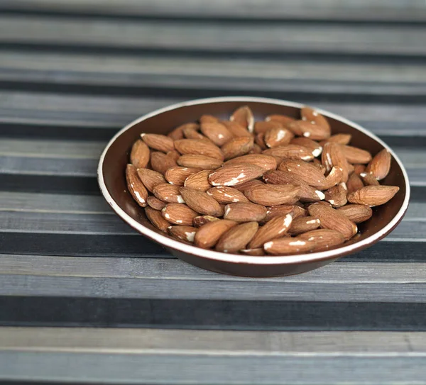 Arka plan görüntüsü için sağlıklı gıda kadar badem fındık kapatın. Doku fındık Kupası plaka üzerinde