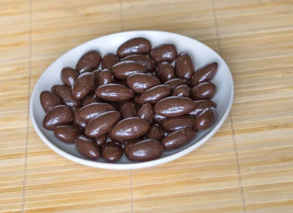 Imagen de la comida cerrar caramelos, leche de chocolate, nueces de almendras oscuras extra. Textura en el fondo de la vista en el plato de copa — Foto de Stock