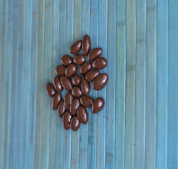 Imagen de la comida cerrar caramelos, leche de chocolate, nueces de almendras oscuras extra. Textura en el fondo de vista superior — Foto de Stock