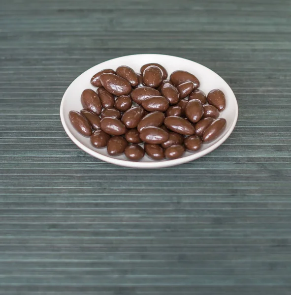 Immagine di cibo da vicino caramelle, latte al cioccolato, mandorle extra scure. Texture sullo sfondo vista sulla piastra tazza — Foto Stock