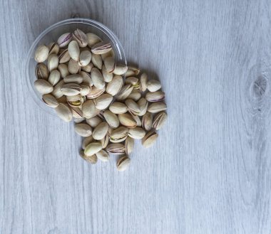 Arka plan görüntüsü için sağlıklı gıda antep fıstığı kapatın. Beyaz gri masa üstü görünümünde doku. Fincan tabağı üzerinde fındık antep fıstığı