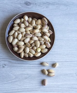 Arka plan görüntüsü için sağlıklı gıda antep fıstığı kapatın. Beyaz gri masa üstü görünümünde doku. Fincan tabağı üzerinde fındık antep fıstığı