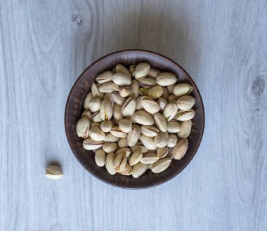 Arka plan görüntüsü için sağlıklı gıda antep fıstığı kapatın. Beyaz gri masa üstü görünümünde doku. Fincan tabağı üzerinde fındık antep fıstığı