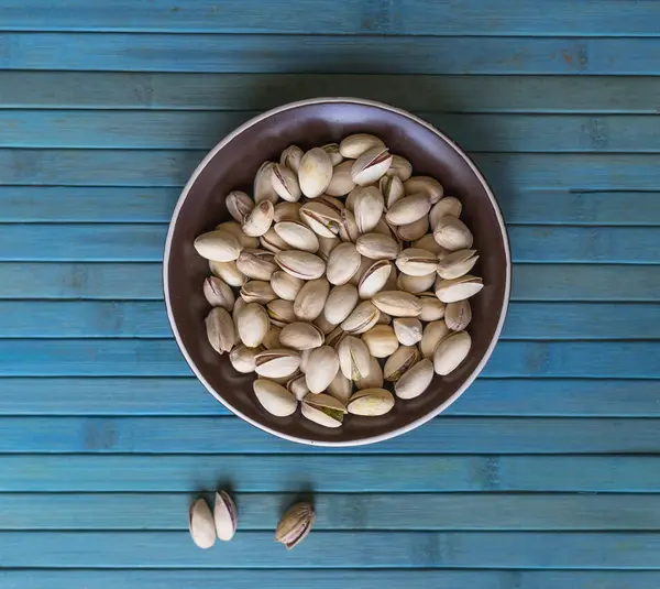 背景画像のための健康的な食品は ピスタチオナッツをクローズアップ カッププレート上のトップビューナッツピスタチオのテクスチャ — ストック写真