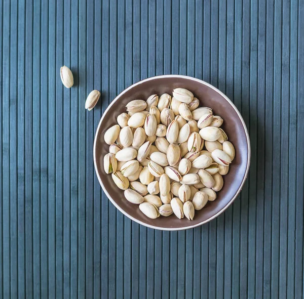 背景画像のための健康的な食品は ピスタチオナッツをクローズアップ カッププレート上のトップビューナッツピスタチオのテクスチャ — ストック写真