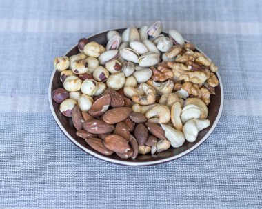 Sağlıklı yiyecekler. Taş doku üst görünümünde fındık karışımı çeşitler. Arka plan görüntüsü için farklı baklagiller koleksiyonu fındık, fıstık, badem, kaju fıstığı, fıstık, ceviz yakın. Görüntü