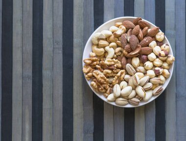 Sağlıklı yiyecekler. Taş doku üst görünümünde fındık karışımı çeşitler. Arka plan görüntüsü için farklı baklagiller koleksiyonu fındık, fıstık, badem, kaju fıstığı, fıstık, ceviz yakın. Görüntü