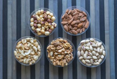 Sağlıklı yiyecekler. Taş doku üst görünümünde fındık karışımı çeşitler. Arka plan görüntüsü için farklı baklagiller koleksiyonu fındık, fıstık, badem, kaju fıstığı, fıstık, ceviz yakın. Görüntü