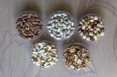 Sağlıklı yiyecekler. Taş doku üst görünümünde fındık karışımı çeşitler. Arka plan görüntüsü için farklı baklagiller koleksiyonu fındık, fıstık, badem, kaju fıstığı, fıstık, ceviz yakın. Görüntü