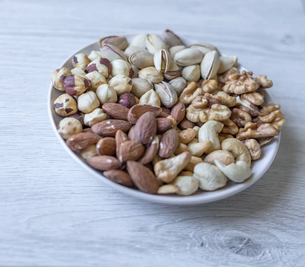 Healthy food. Nuts mix assortment on white grey table top view. Collection of different legumes for background image close up nuts, pistachios, almond, cashew nuts, peanut, walnut. image