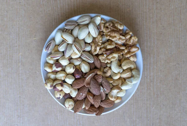 健康的な食べ物 ナットは 白い灰色のテーブルトップビューに品揃えをミックスします 背景画像クローズアップナッツ ピスタチオ アーモンド カシューナッツ ピーナッツ クルミのための異なる豆のコレクション イメージ — ストック写真