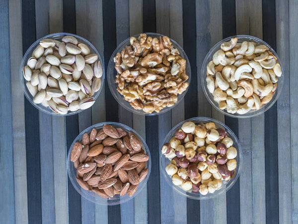 Healthy food. Nuts mix assortment on stone texture top view. Collection of different legumes for background image close up nuts, pistachios, almond, cashew nuts, peanut, walnut. image