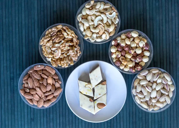 Oriental dessert halva with pistachio, almond, cashew nuts, peanut, walnut  on a  plate. Image. Healthy food. Nuts mix assortment. closeup of sweets from Iran popular in many other regions of the world, at the Machane Yehuda Market, Jerusalem, Israel