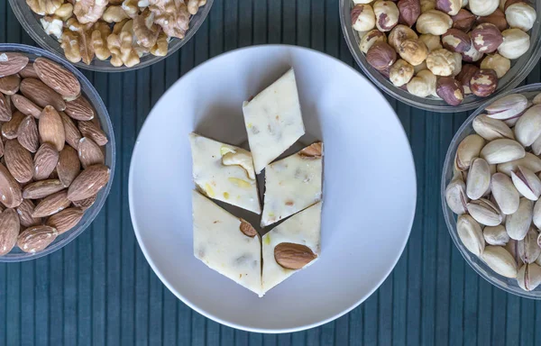 Oriental dessert halva with pistachio, almond, cashew nuts, peanut, walnut  on a  plate. Image. Healthy food. Nuts mix assortment. closeup of sweets from Iran popular in many other regions of the world, at the Machane Yehuda Market, Jerusalem, Israel