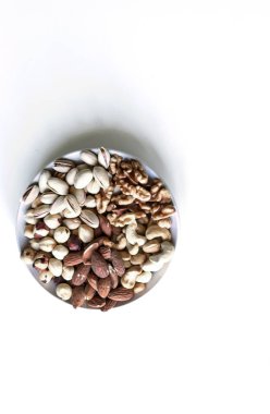 Sağlıklı yiyecekler. Somunlar beyaz gri masa üstü görünümünde çeşitli karıştırın. Arka plan görüntüsü için farklı baklagiller koleksiyonu yakın fındık, antep fıstığı, badem, kaju fıstığı, fıstık, ceviz. Görüntü