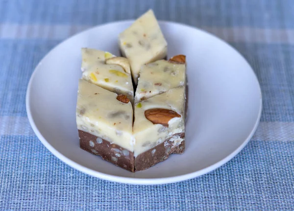 Oriental dessert halva with pistachio, almond, cashew nuts, peanut, walnut  on a  plate. Image. Healthy food. closeup of sweets from Iran popular in many other regions of the world, at the Machane Yehuda Market, Turkish Delight. Isolated on backgroun