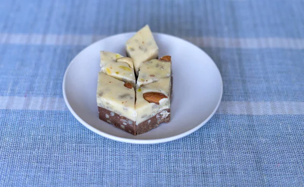 Oriental dessert halva with pistachio, almond, cashew nuts, peanut, walnut  on a  plate. Image. Healthy food. closeup of sweets from Iran popular in many other regions of the world, at the Machane Yehuda Market, Turkish Delight. Isolated on backgroun