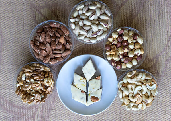 Oriental dessert halva with pistachio, almond, cashew nuts, peanut, walnut  on a  plate. Image. Healthy food. Nuts mix assortment. closeup of sweets from Iran popular in many other regions of the world, at the Machane Yehuda Market, Turkish Delight. 