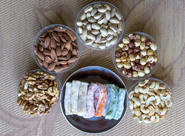 Traditional Turkish Delight. Oriental dessert on a  plate. Isolated on background. Eastern delicacy sweets. Healthy food. Nuts mix assortment. Collection of different legumes for image close up nuts, pistachios, almond, cashew nuts, peanut, walnut on