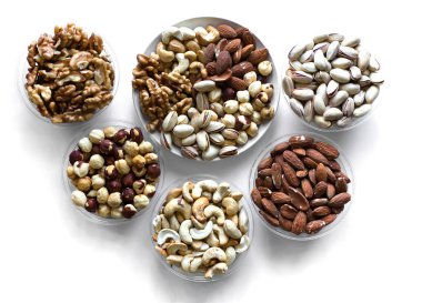 Sağlıklı yiyecekler. Somunlar beyaz gri masa üstü görünümünde çeşitli karıştırın. Arka plan görüntüsü için farklı baklagiller koleksiyonu yakın fındık, antep fıstığı, badem, kaju fıstığı, fıstık, ceviz. Görüntü