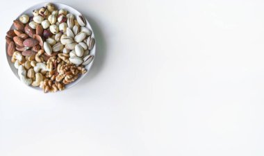 Sağlıklı yiyecekler. Somunlar beyaz gri masa üstü görünümünde çeşitli karıştırın. Arka plan görüntüsü için farklı baklagiller koleksiyonu yakın fındık, antep fıstığı, badem, kaju fıstığı, fıstık, ceviz. Görüntü