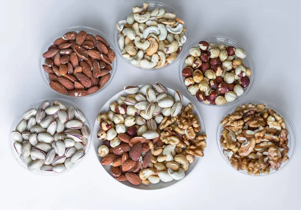 Healthy food. Nuts mix assortment on white grey table top view. Collection of different legumes for background image close up nuts, pistachios, almond, cashew nuts, peanut, walnut. image